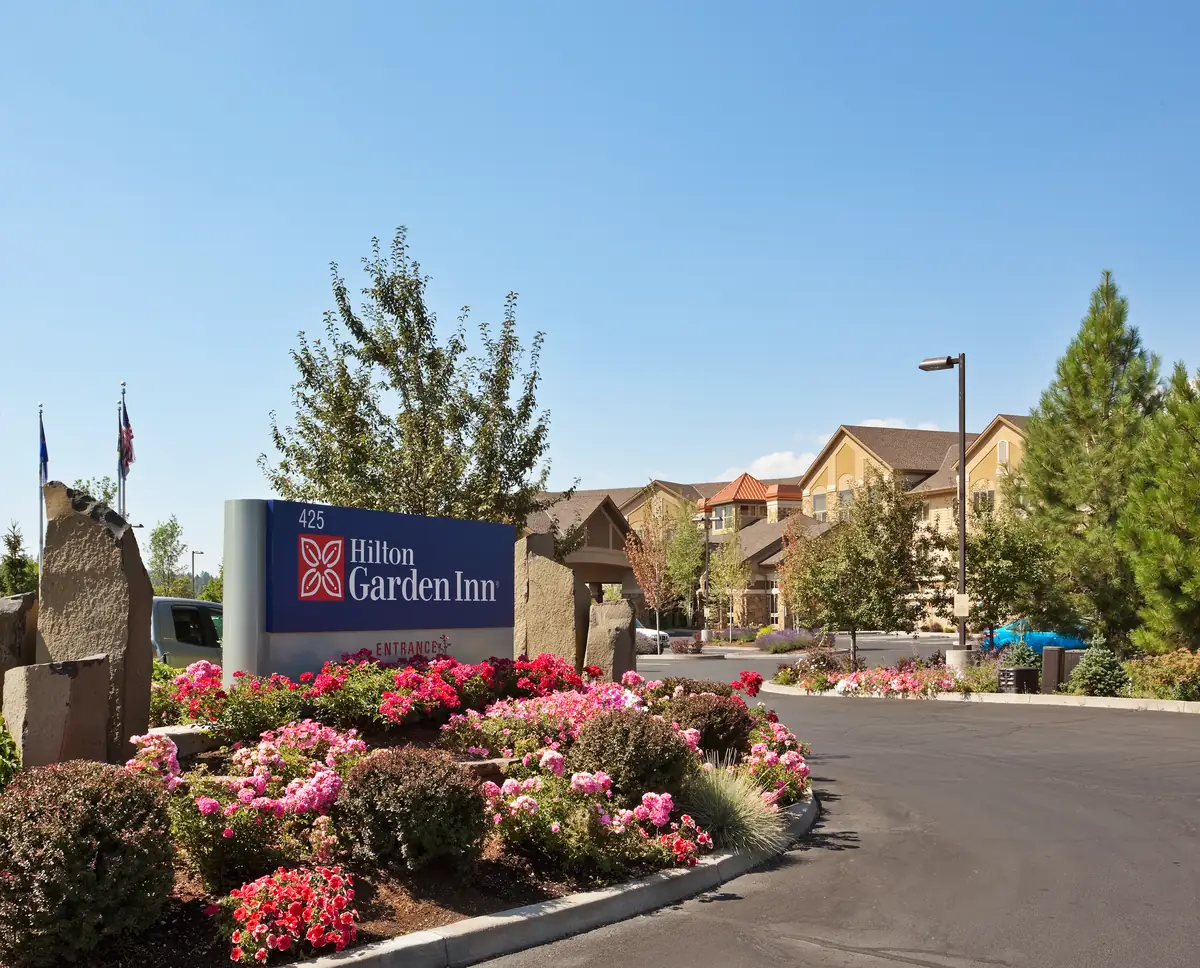 Hilton Garden Inn Bend exterior with flowers and mountain-region landscaping